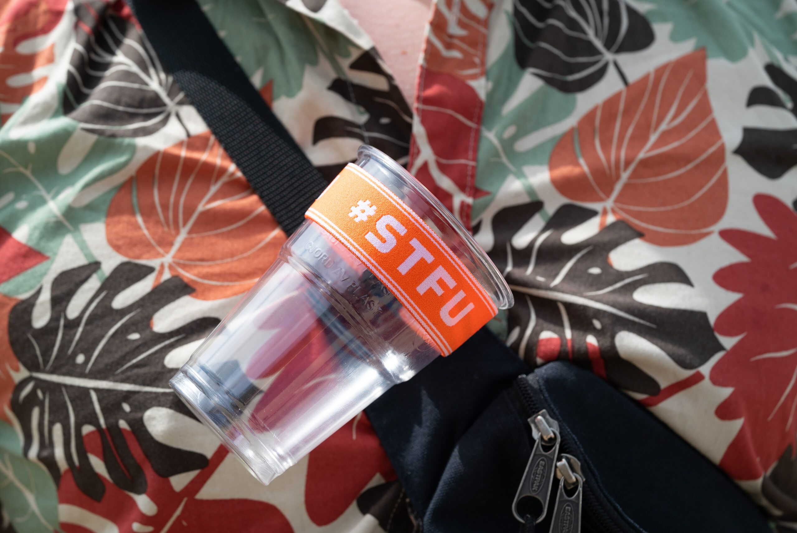 De STFU Festival Bekerhouder bevestigd aan een nektasje De STFU Festival Bekerhouder bevestigd aan een nektasje